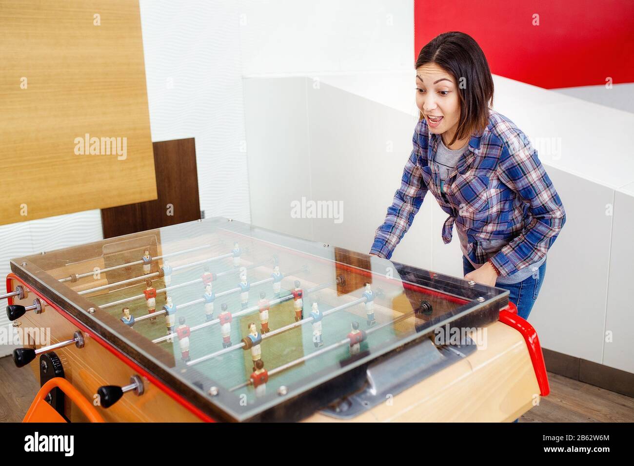 Two happy women friends playing table football at leisure time Stock Photo