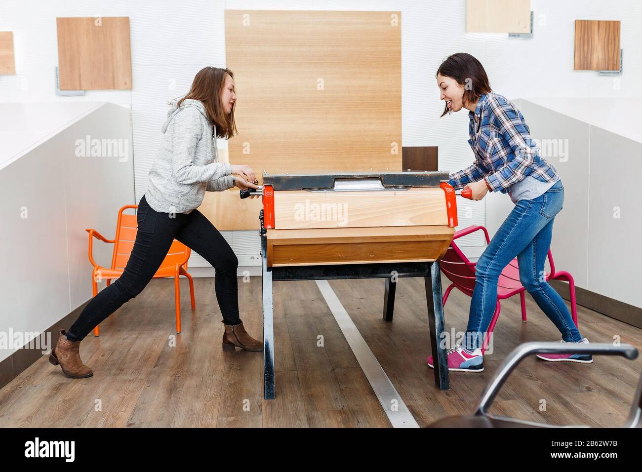 Two happy women friends playing table football at leisure time Stock Photo