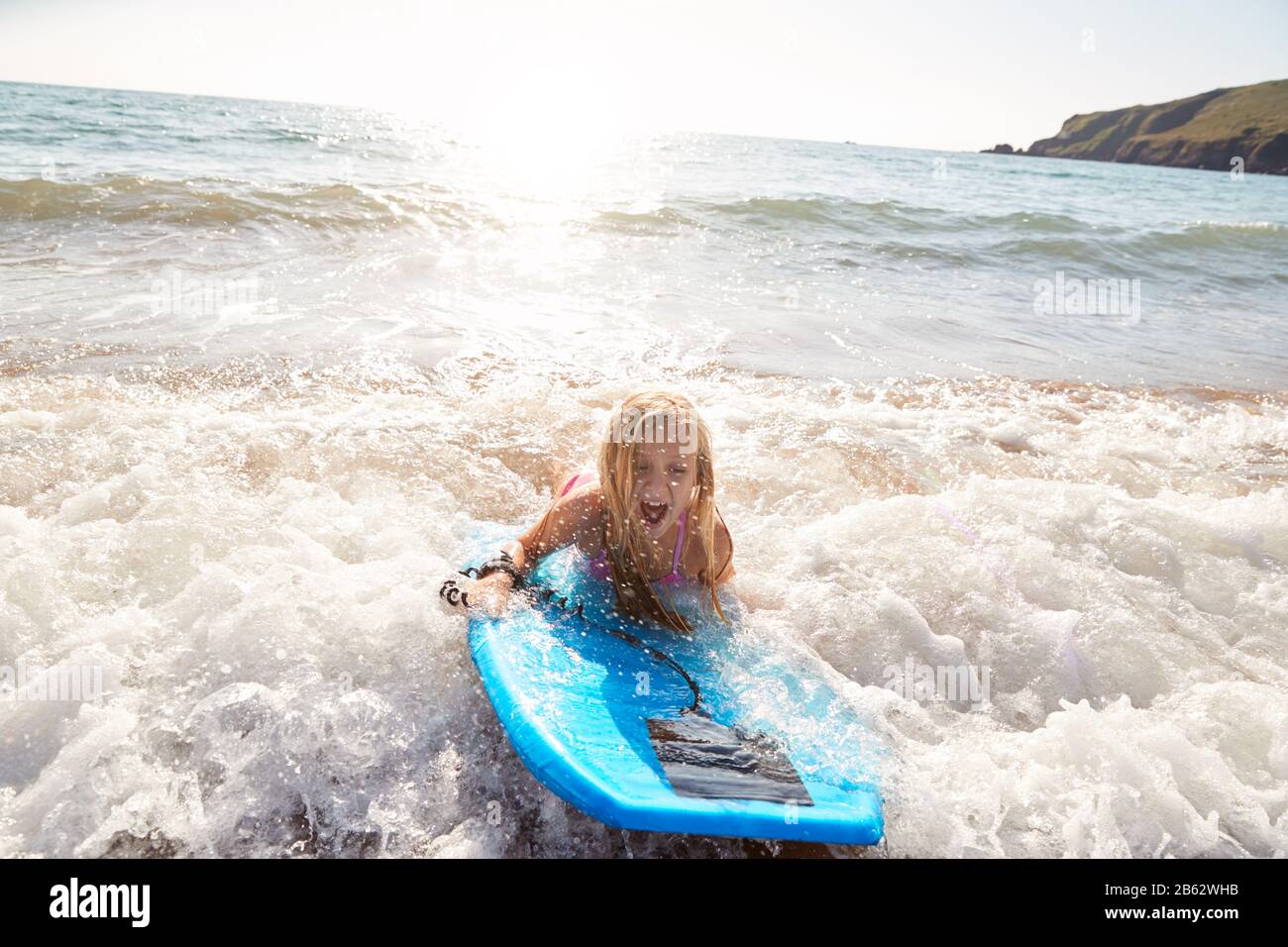 Girl Playing In Sea With Bodyboard On Summer Beach Vacation Stock Photo