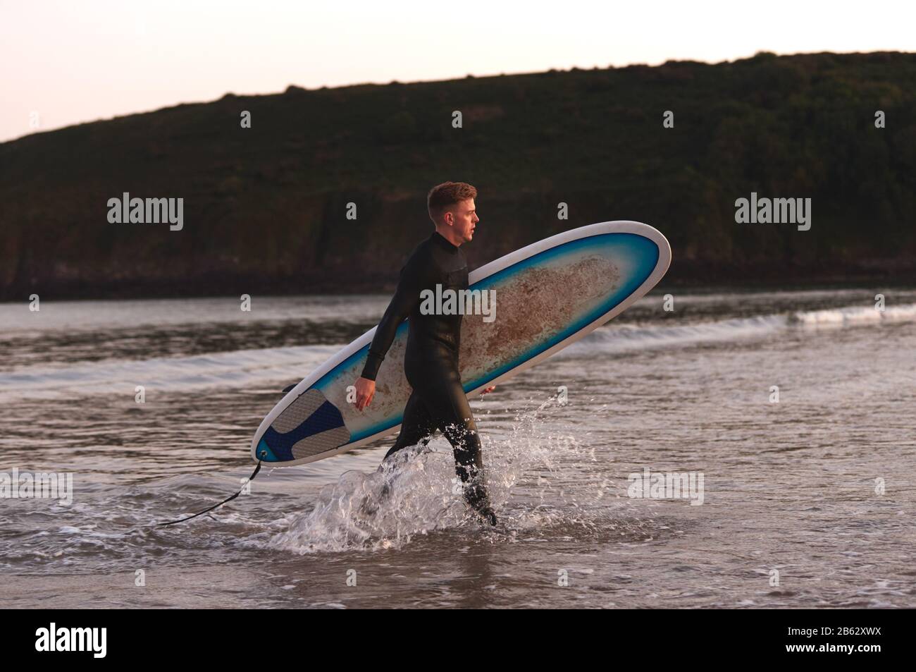 Surfer wearing wetsuit walks out hi-res stock photography and images ...