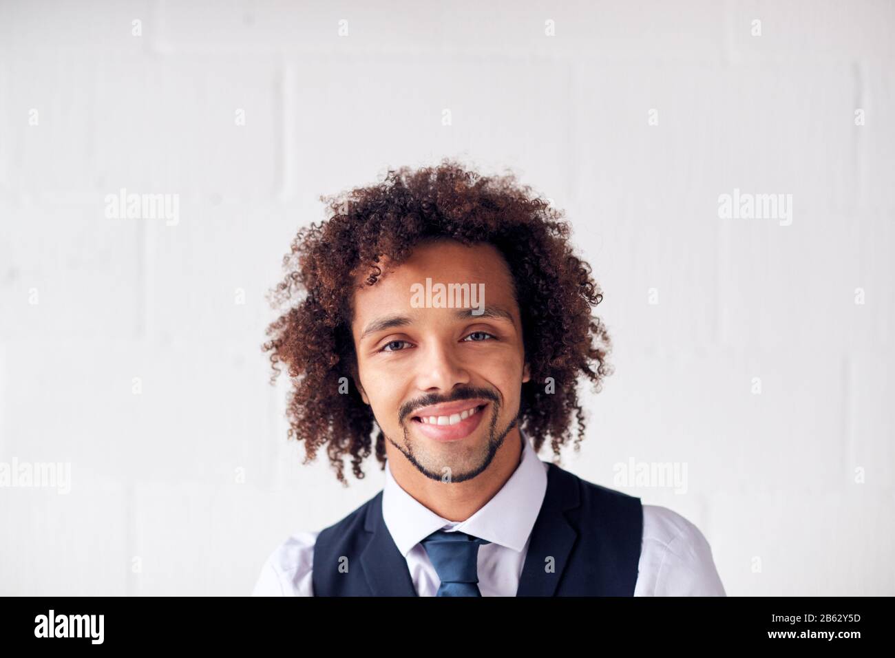 Portrait Of Confident Young Businessman Wearing Suit Standing Against ...