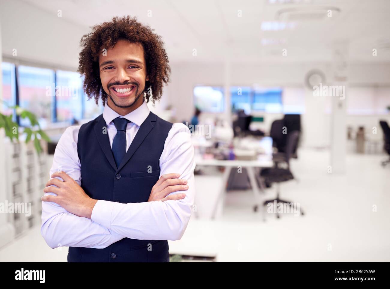 Portrait Of Confident Young Businessman Wearing Suit Standing In Modern ...