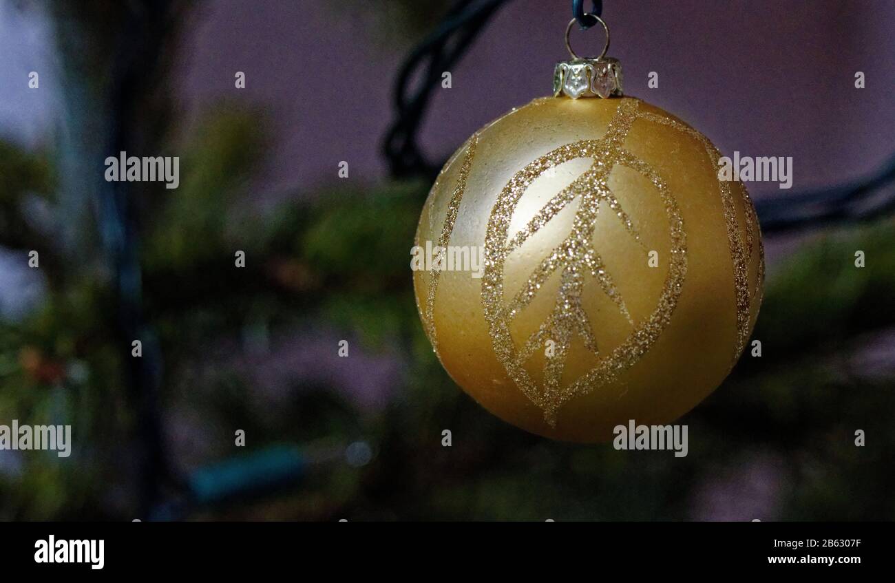 Golden bauble with leaf pattern hanging on a Christmas tree Stock Photo
