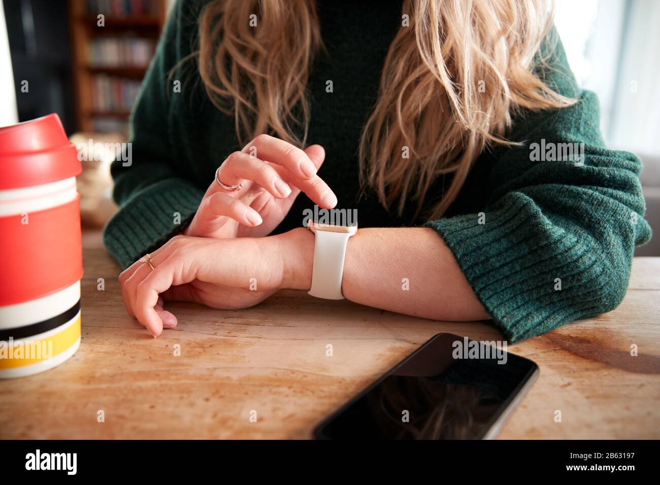 Close Up Of Woman Using Smart Watch Sitting At Table  In Cafe Stock Photo