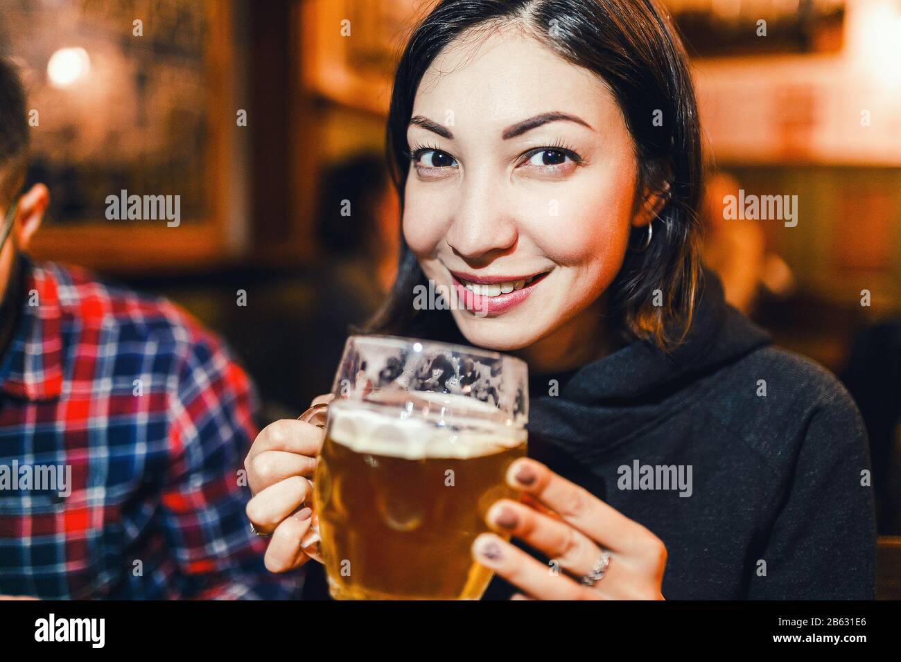 Asian woman drinking beer in a traditional Czech beer house in Prague