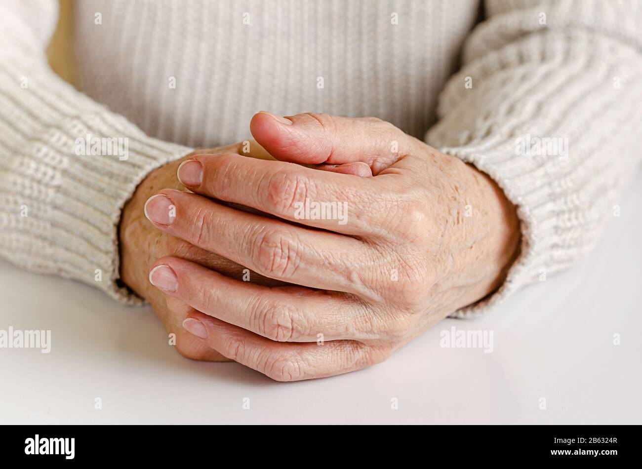 An elderly woman holding hand together on white background. Stock Photo