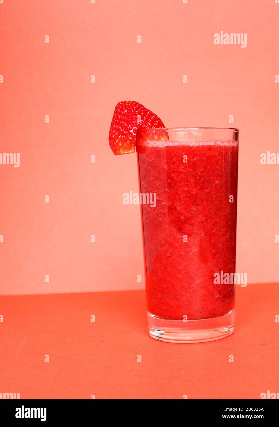 Single-color opaque cocktail, orange, red refreshing in a jug with ice cubes with the taste of tomato, grapeprut, strawberry. Side view. Isolated whit Stock Photo