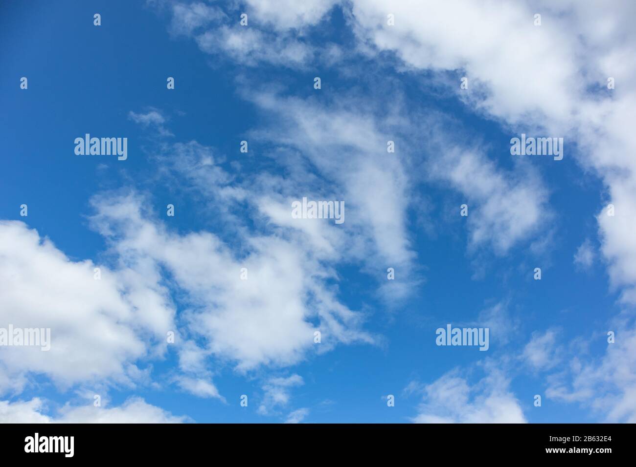 Vibrant blue sky with white fluffy clouds background Stock Photo - Alamy