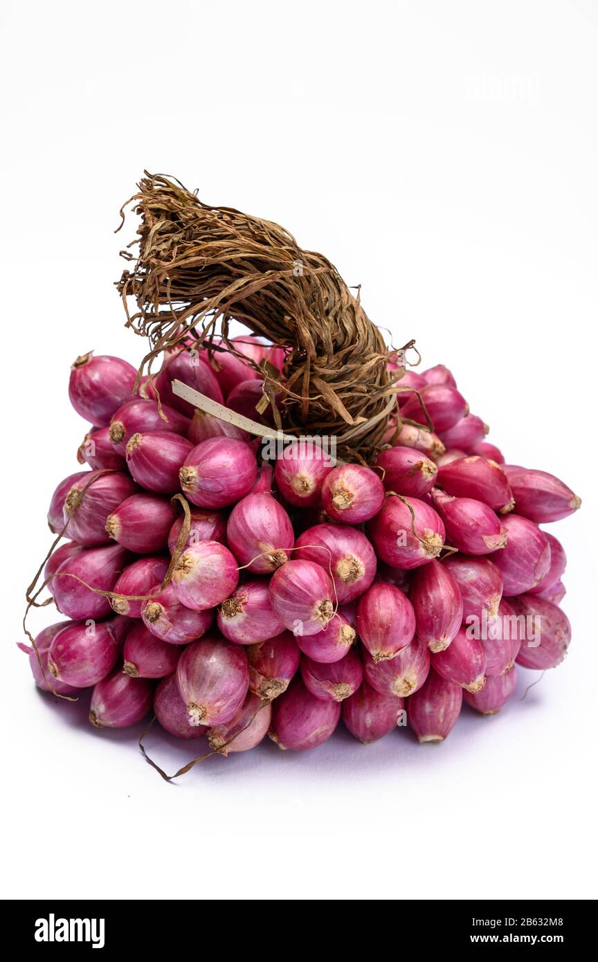 Bunch of high quality small red shallot sambar onions from India isolated Stock Photo