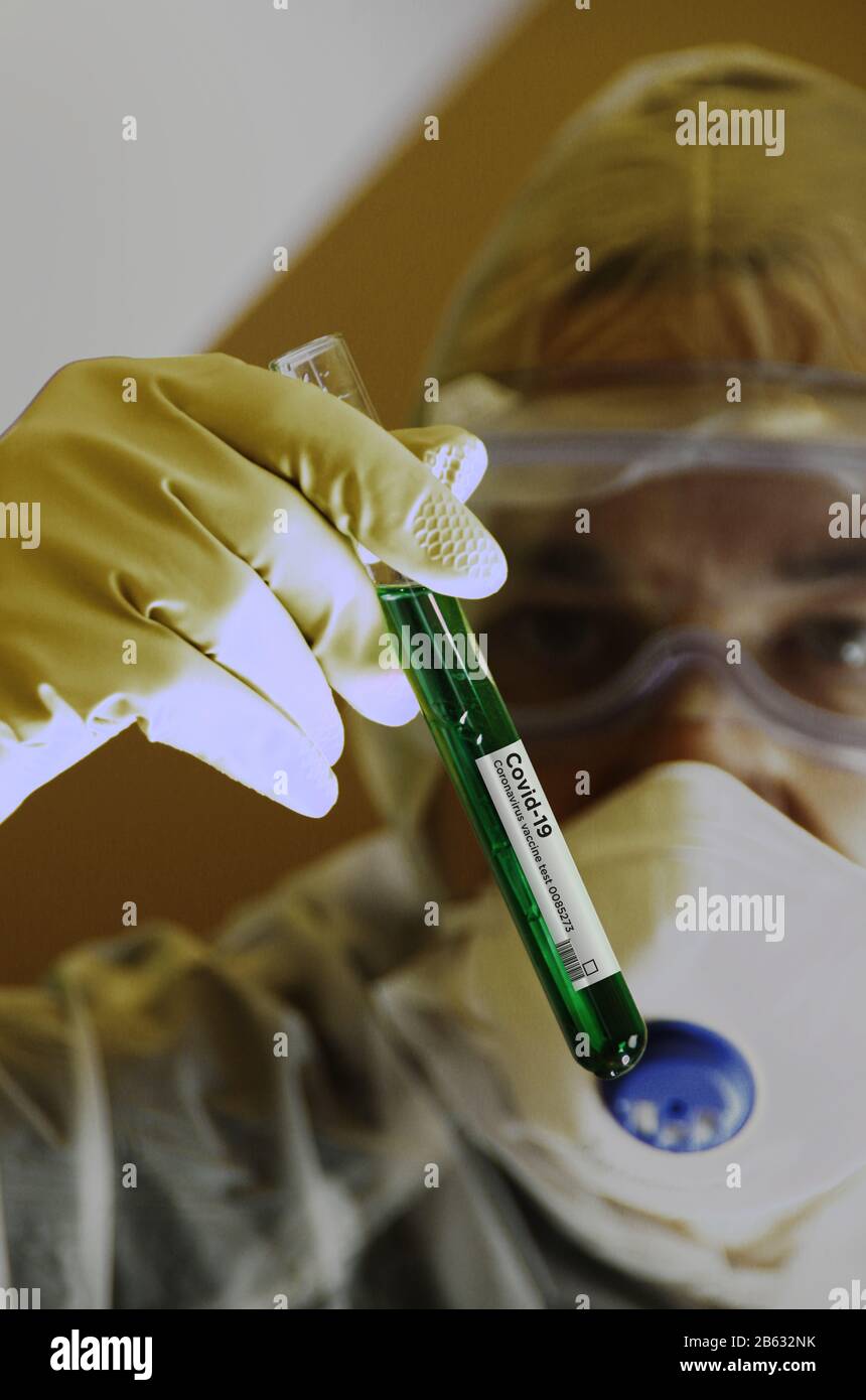 Coronavirus Covid-19 vaccine search. Scientist in protection glasses and mask with test tube in glove hand. Concept of science, biology, health, medic Stock Photo