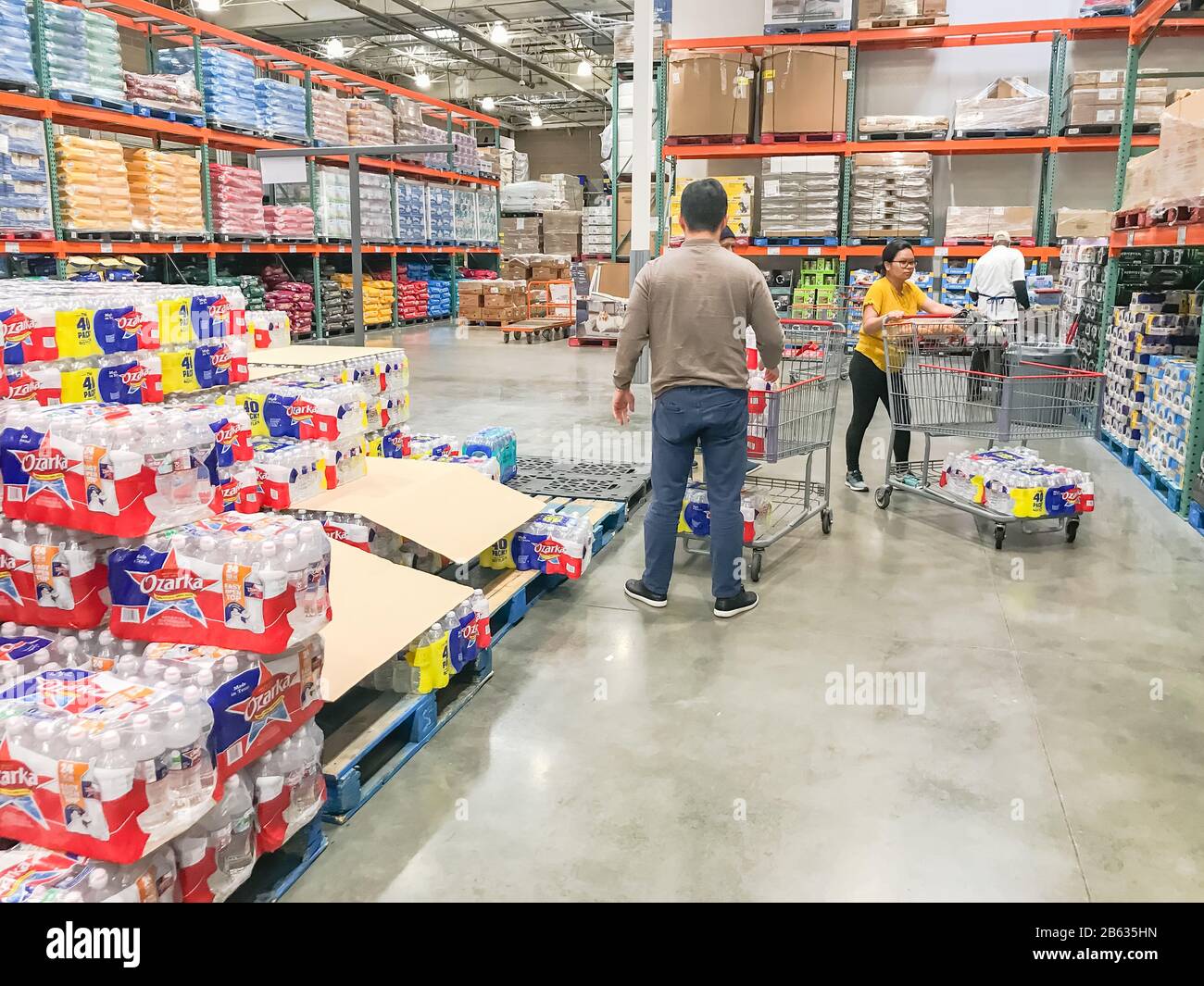 Shoppers stocking bottled water at Costcow Warehouse store Stock Photo