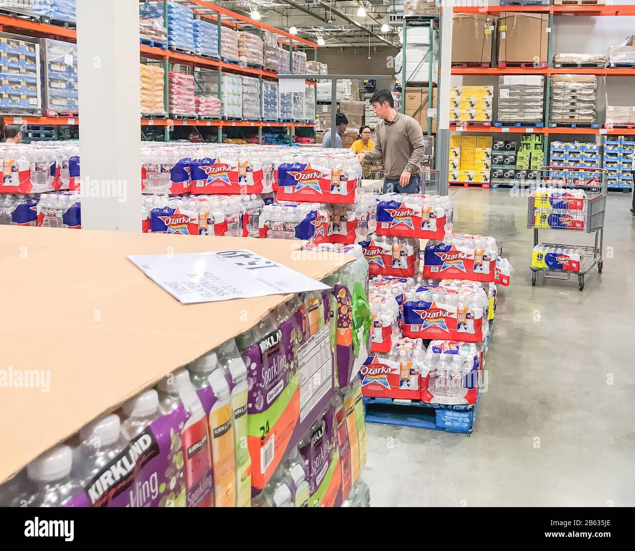 Shoppers stocking bottled water at Costcow Warehouse store Stock Photo