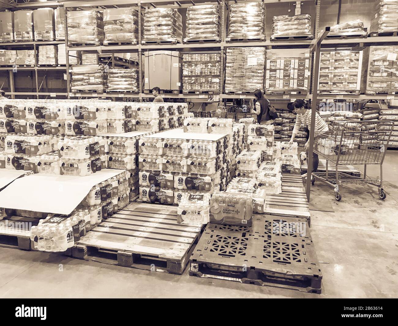 Shoppers stocking bottled water at Costcow Warehouse store Stock Photo