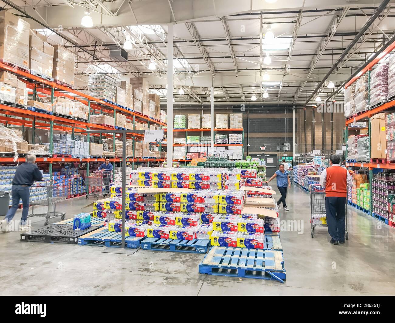 Shoppers stocking bottled water at Costcow Warehouse store Stock Photo