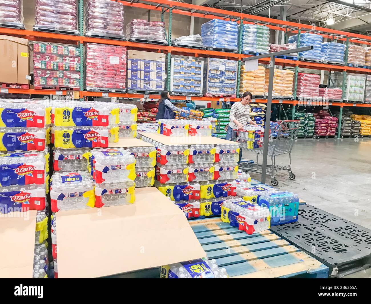 Shoppers stocking bottled water at Costcow Warehouse store Stock Photo