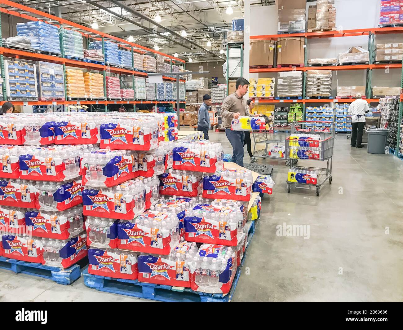Shoppers stocking bottled water at Costcow Warehouse store Stock Photo