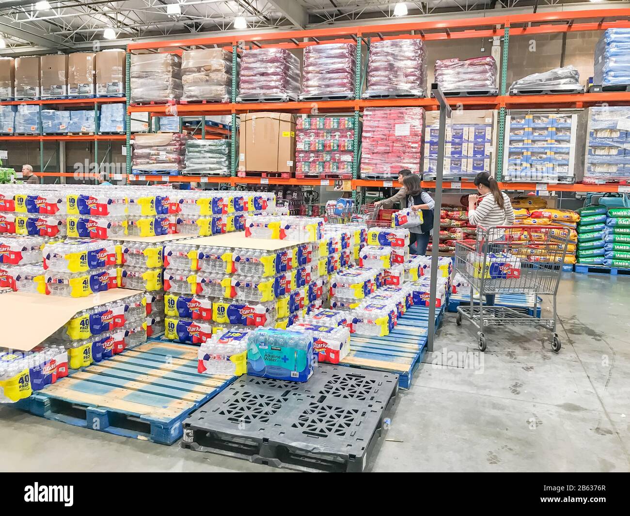 Shoppers stocking bottled water at Costcow Warehouse store Stock Photo