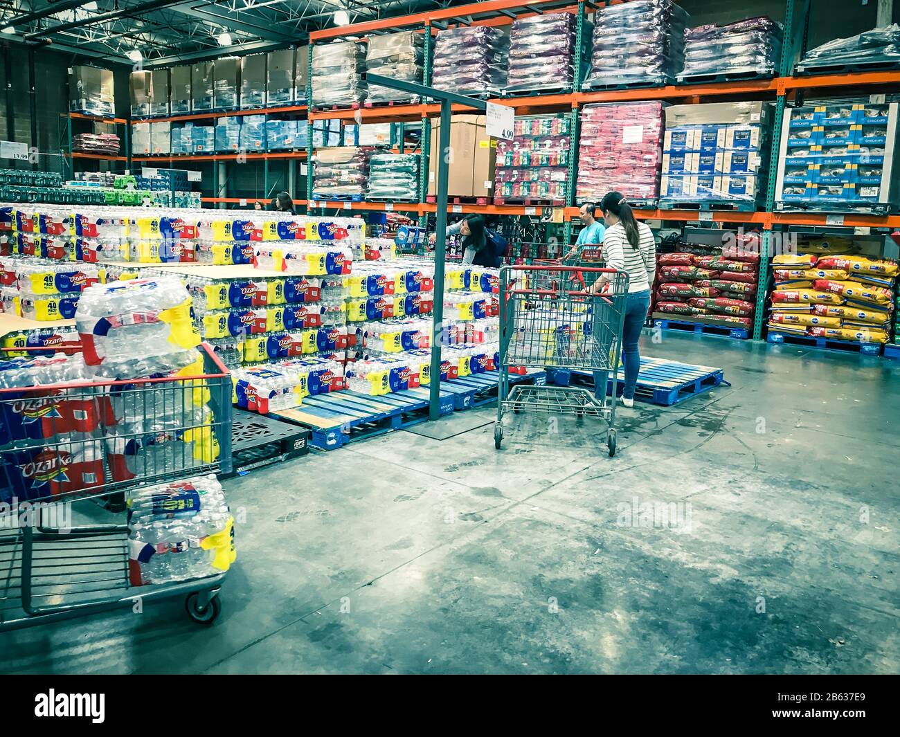 Shoppers stocking bottled water at Costcow Warehouse store Stock Photo