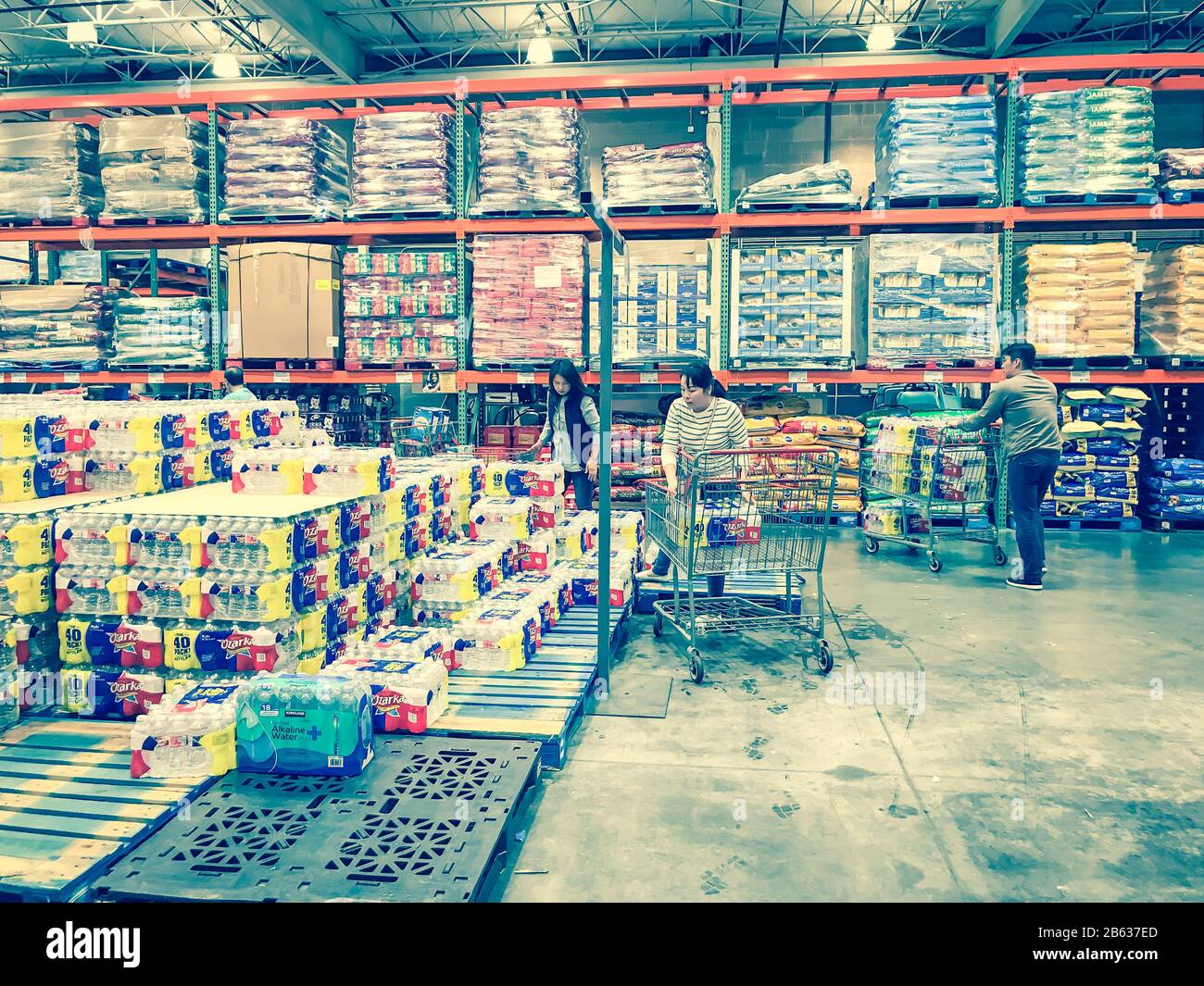 Shoppers stocking bottled water at Costcow Warehouse store Stock Photo