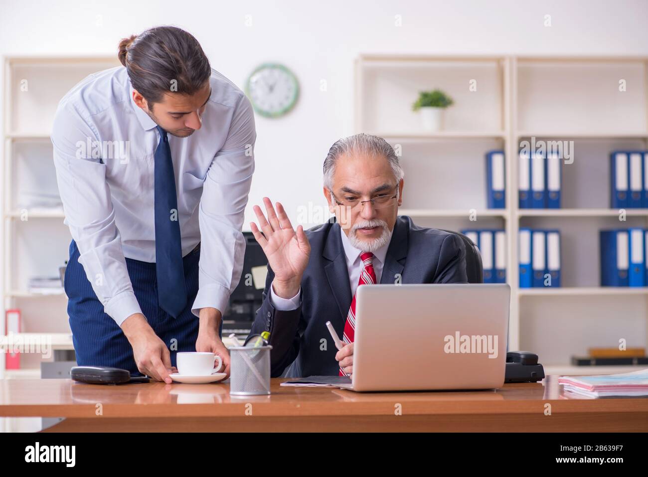 Old boss and young employee in the office Stock Photo Alamy