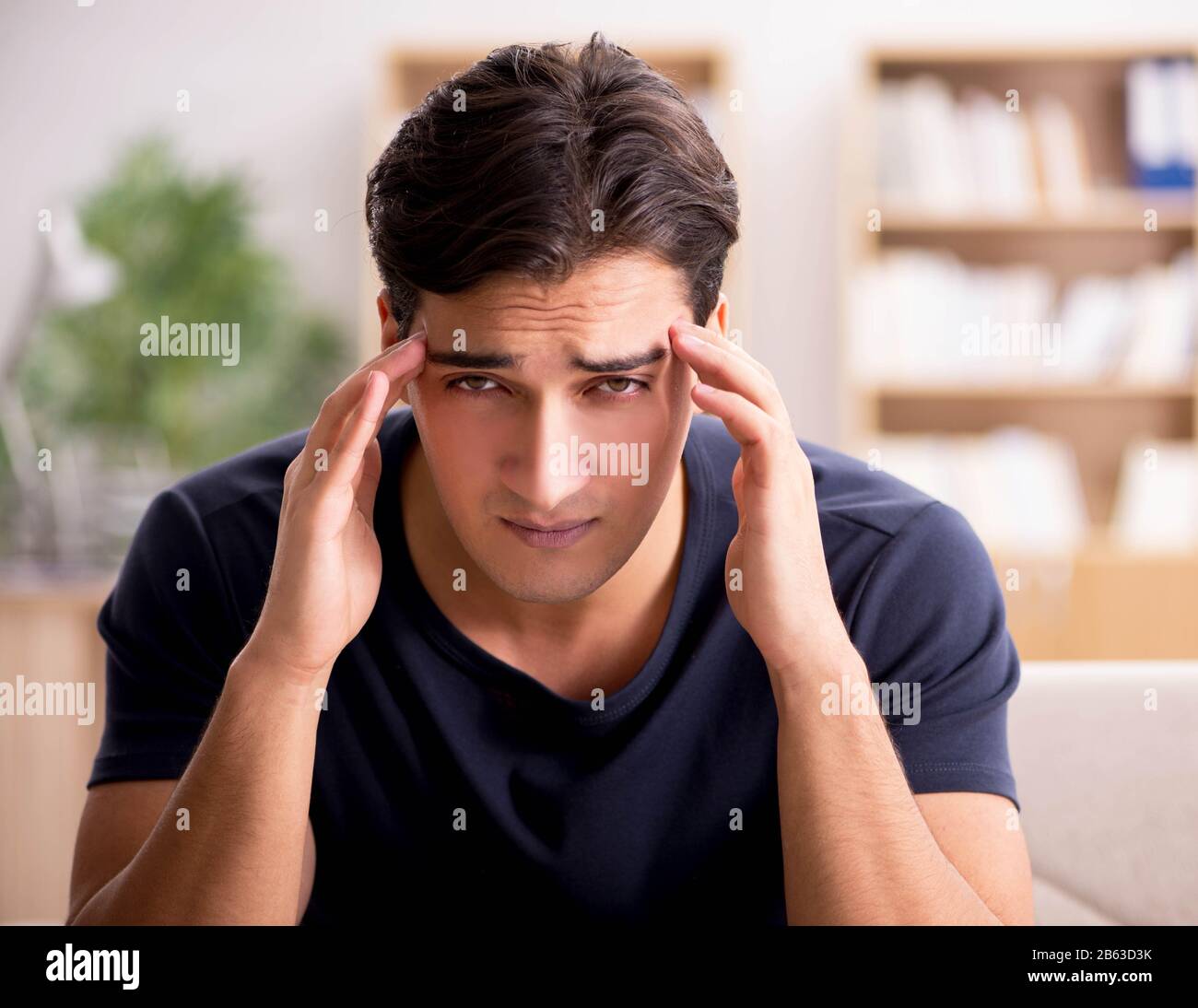 The young handsome man suffering from pain Stock Photo - Alamy