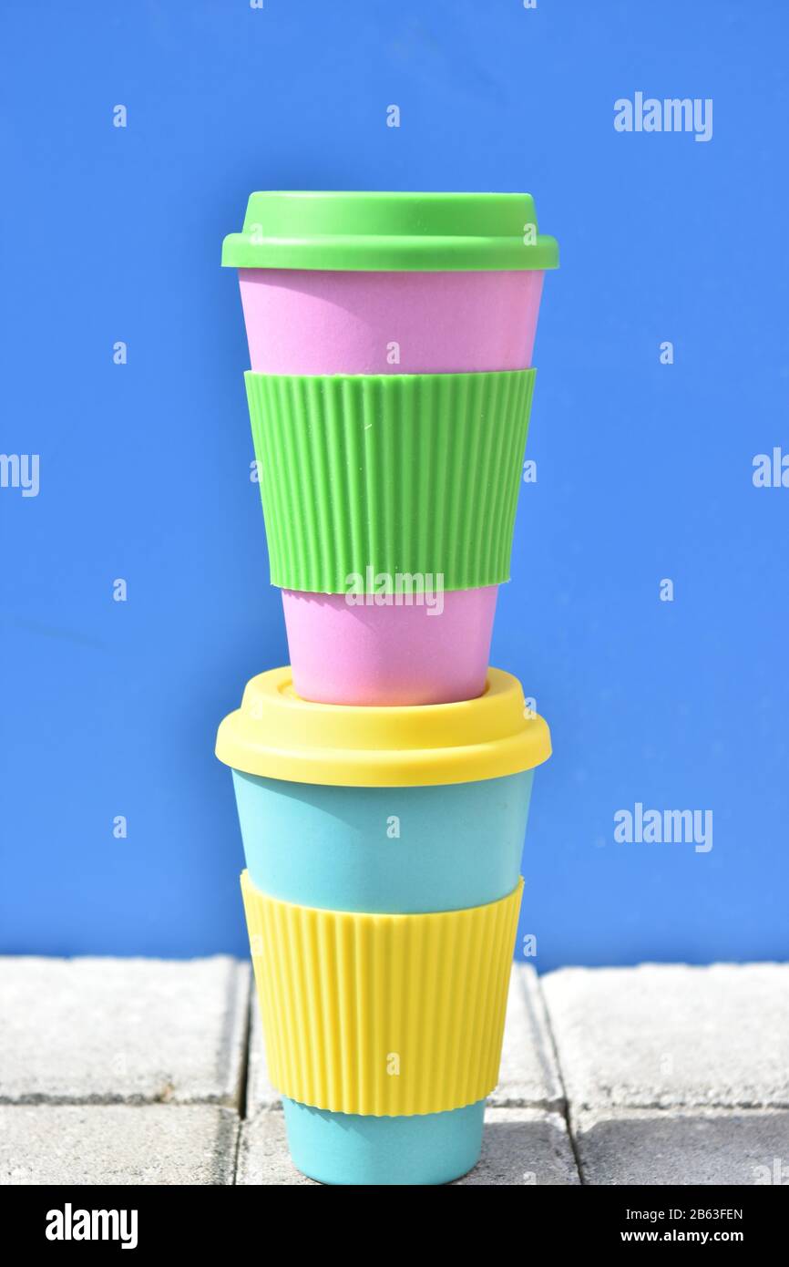 bamboo reusable coffee or tea cups mugs with multicolor silicone cap Stock Photo