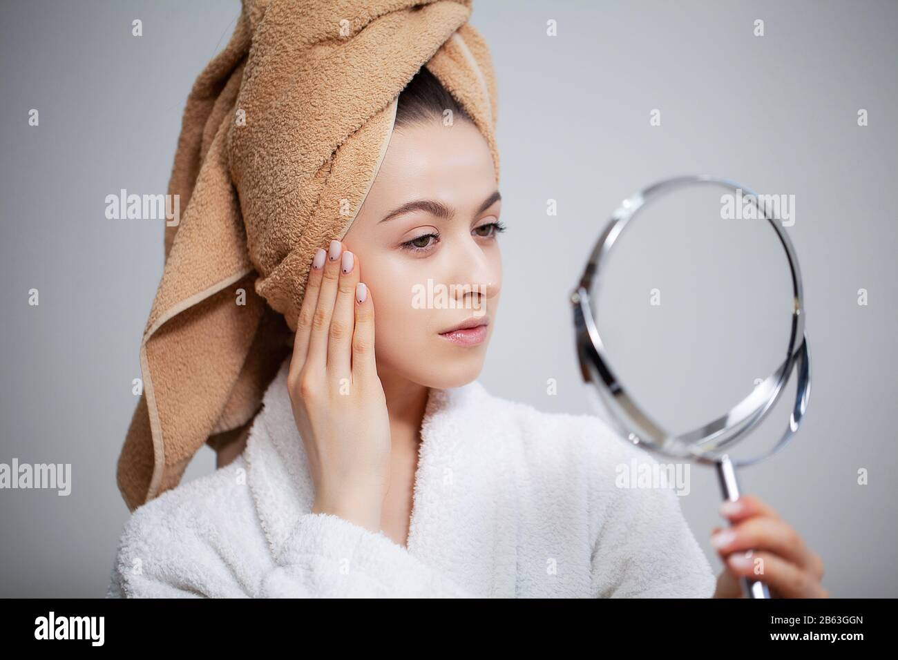 Pretty woman looks in the mirror after a shower Stock Photo Alamy