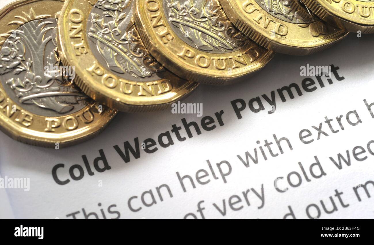 COLD WEATHER PAYMENT LEAFLET WITH ONE POUND COINS RE WINTER FUEL PENSIONS RETIREMENT PENSIONERS WINTER  ETC UK Stock Photo