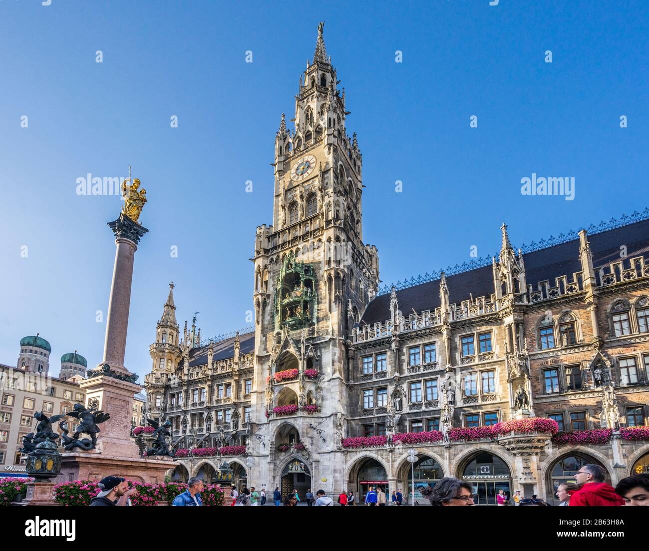 the richly decorated facade of the New Munich Town Hall (Neues Rathaus) with its 85 m high Rathausturm and Mariensäule column at Marienplatz, München- Stock Photo