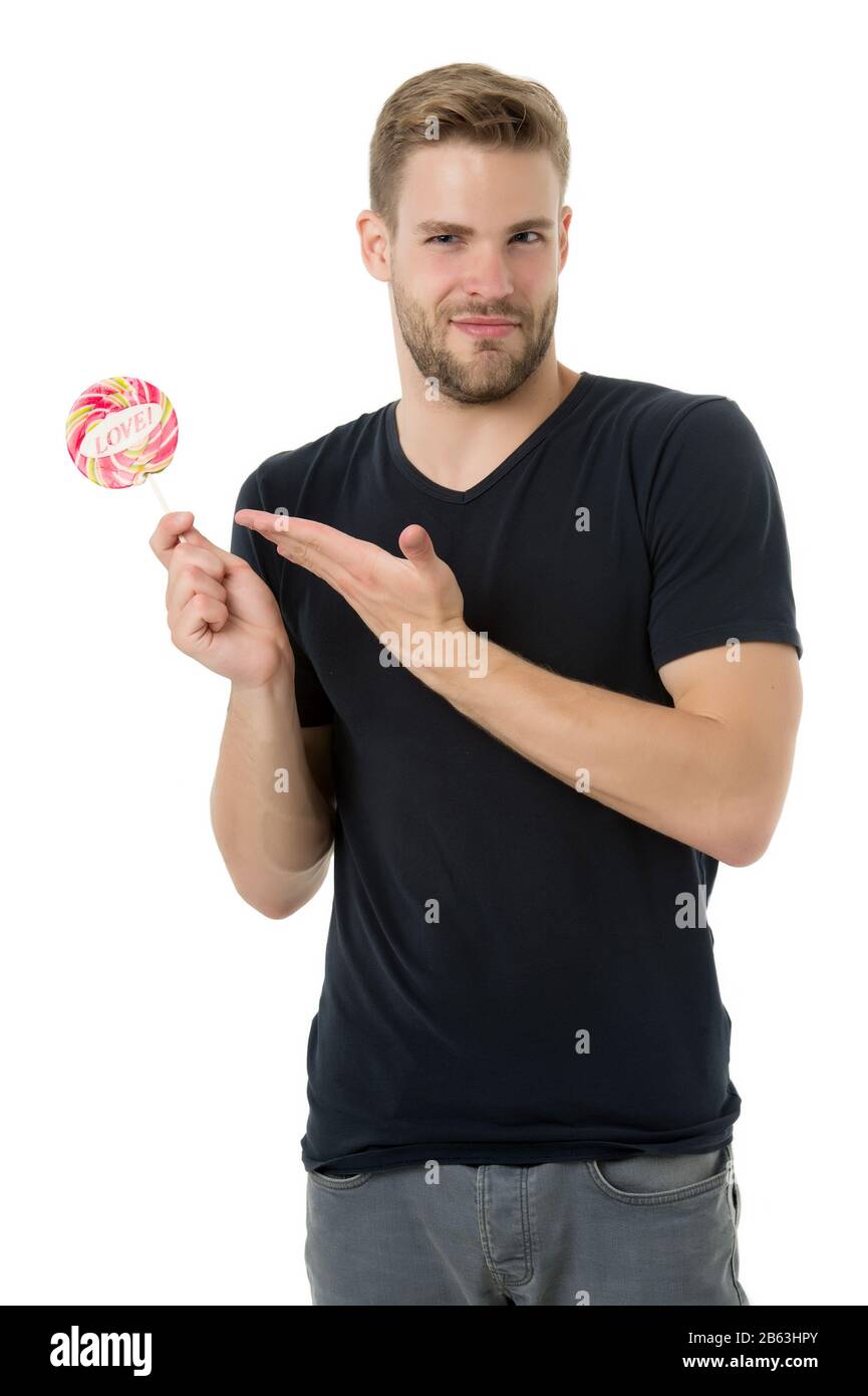 Candy made for love. Handsome guy show candy with love word lettering. Unshaven bachelor hold candy on stick. Candy shop. Valentines day lollipop or sucker. Sugary treat for your Valentine. Stock Photo