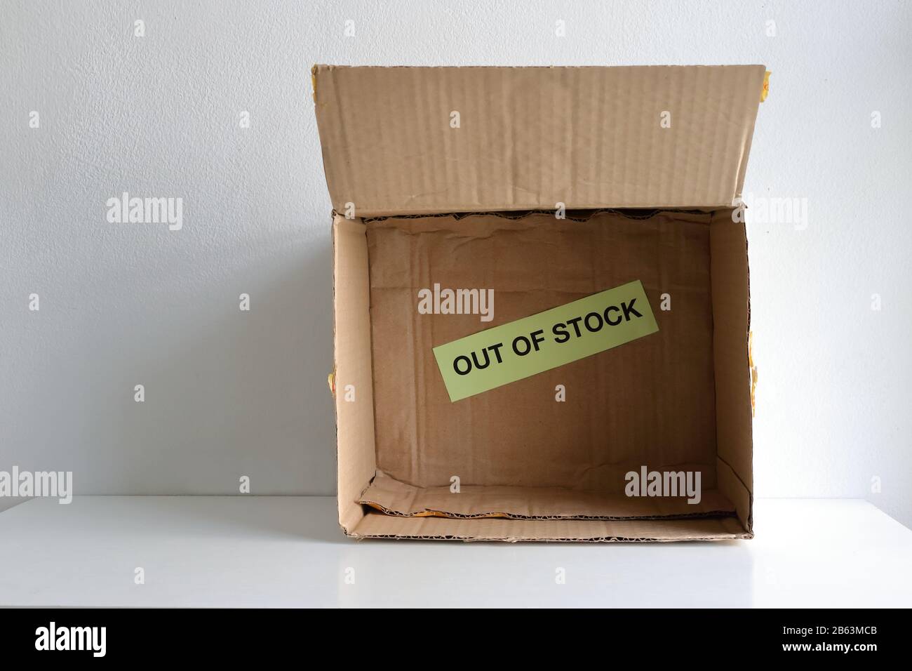 OUT OF STOCK sign in empty carton. People hoarding supplies such as face mask, hand gel, food, toilet paper etc. as a result of cover-19 outbreak Stock Photo