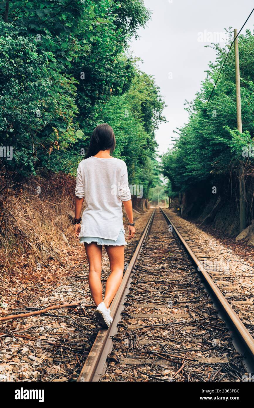 Girl balancing on the train rail thinking on future Stock Photo