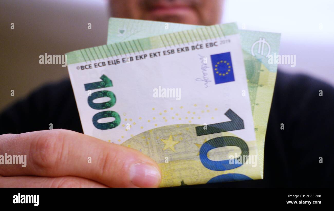 100 euro banknotes in the hand of an unrecognizable man Stock Photo