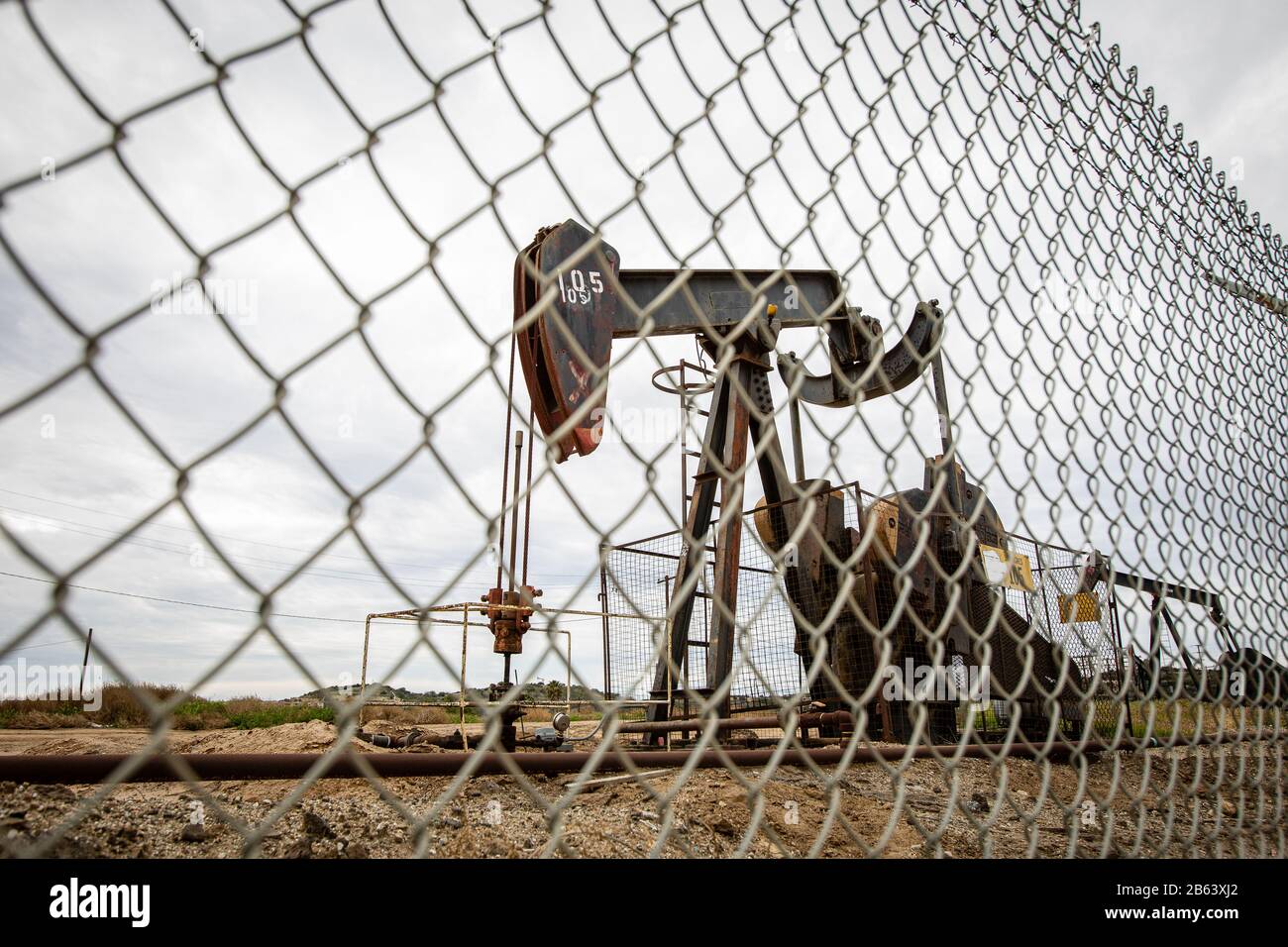 Oil Pump in Cloudy Rough Weather with Chain Link Fence Stock Photo Alamy