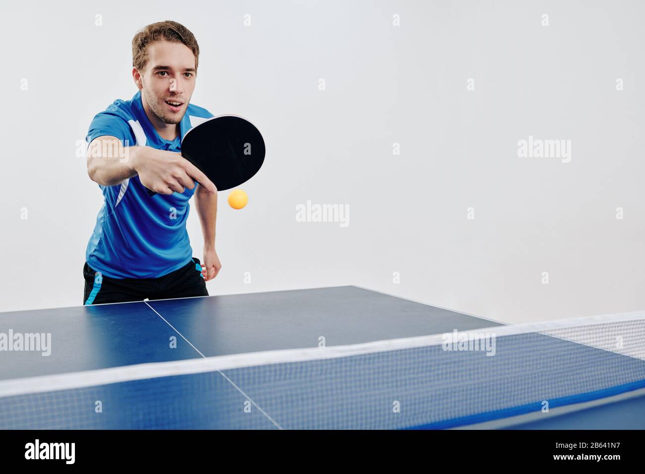 Young sportsman playing ping pong at competition and hitting the ball back  Stock Photo - Alamy