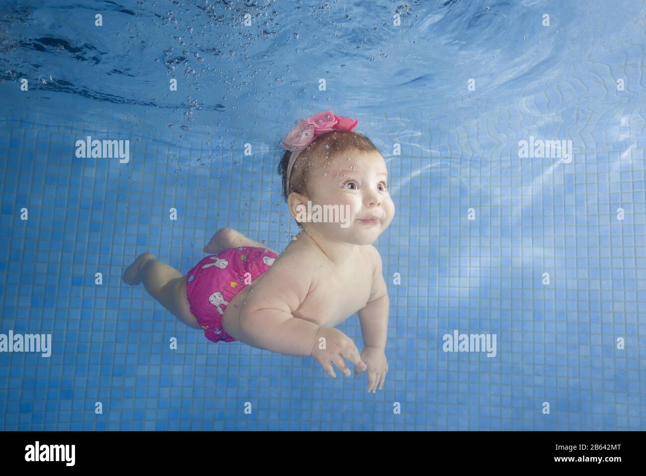 Little baby learning to swim underwater in a swimming pool, Ukraine Stock Photo