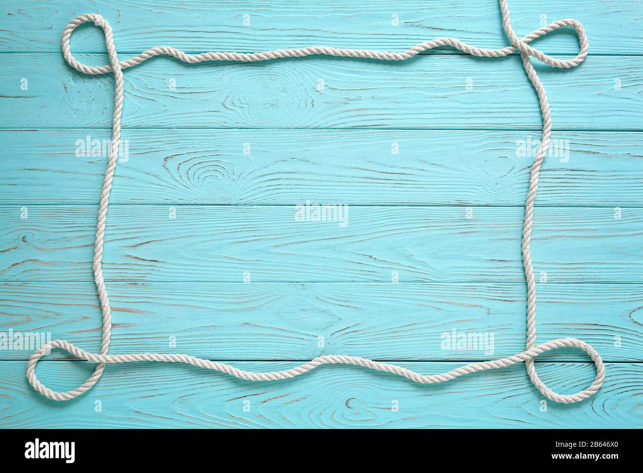 Frame made of white rope on a wooden blue background. Summer time sea vacation concept. Place for your text. Stock Photo