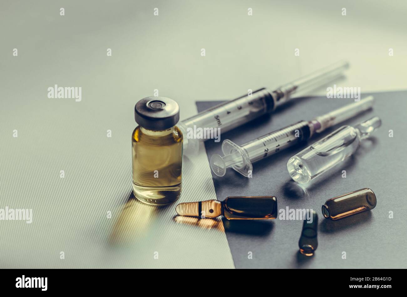 Randomly scattered Medicines on the table. Syringes and ampoules on a gray background. Eye level shooting. Close-up. Selective focus. Without people. Stock Photo