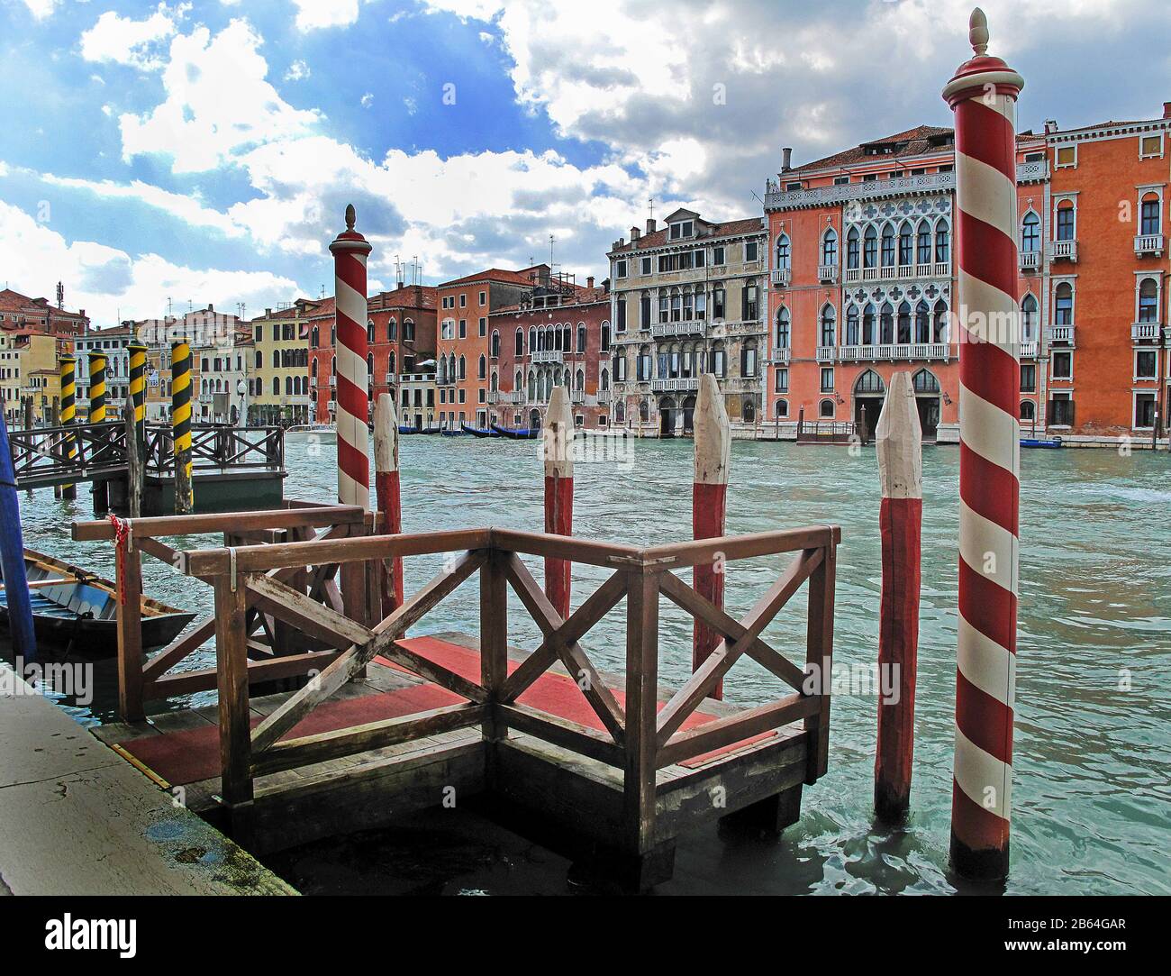 Gondola boat mooring stop with red and white stripes vertical barber poles Venice Italy Stock Photo