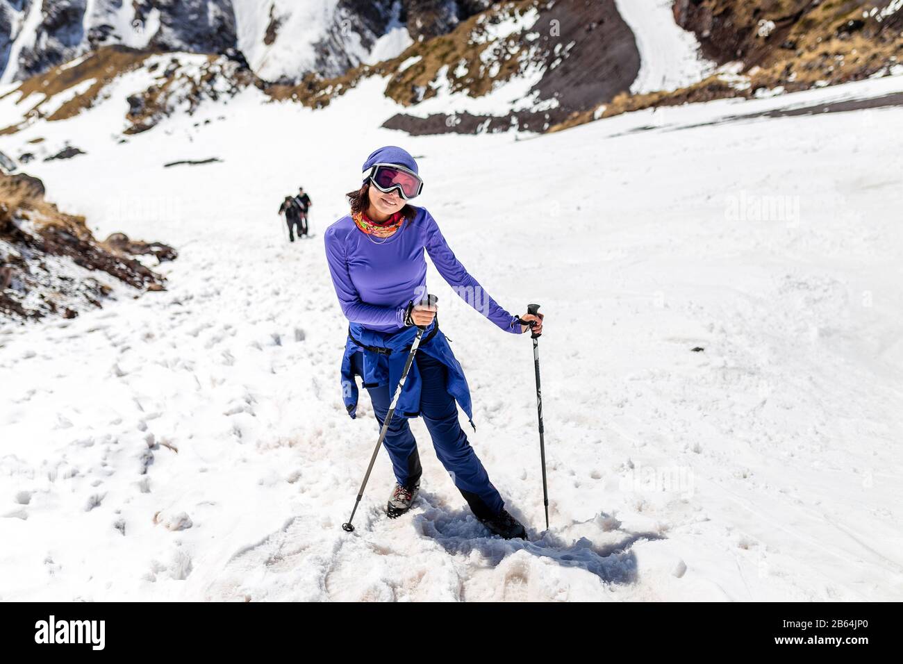 Woman hiking on sunny winter day in mountain landscape. Female hiker in  warm bright outfit clothes enjoying trail walk on snow covered track Stock  Photo - Alamy