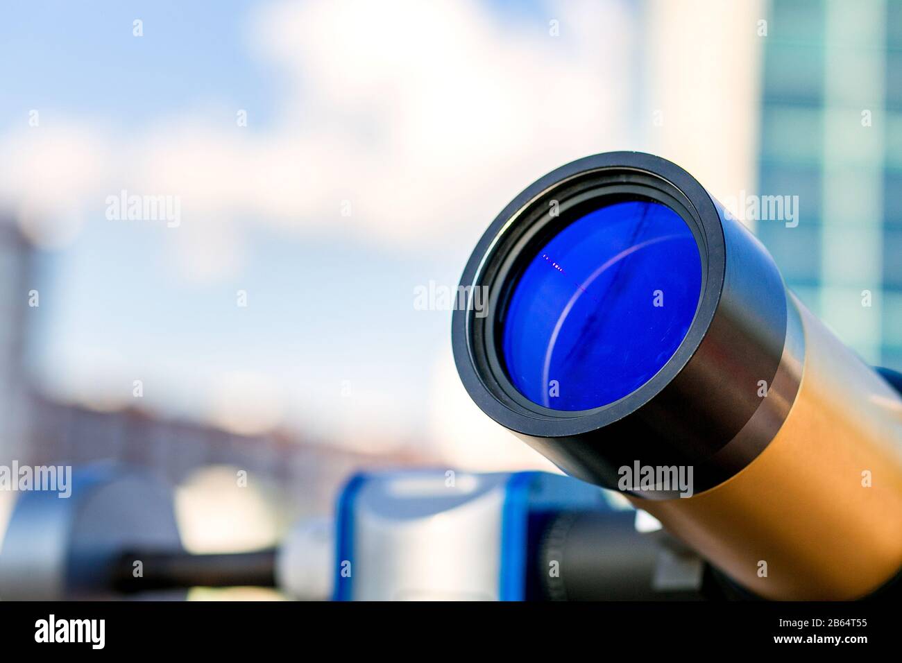 Golden paid telescope stands outdoors over blue sky background Stock