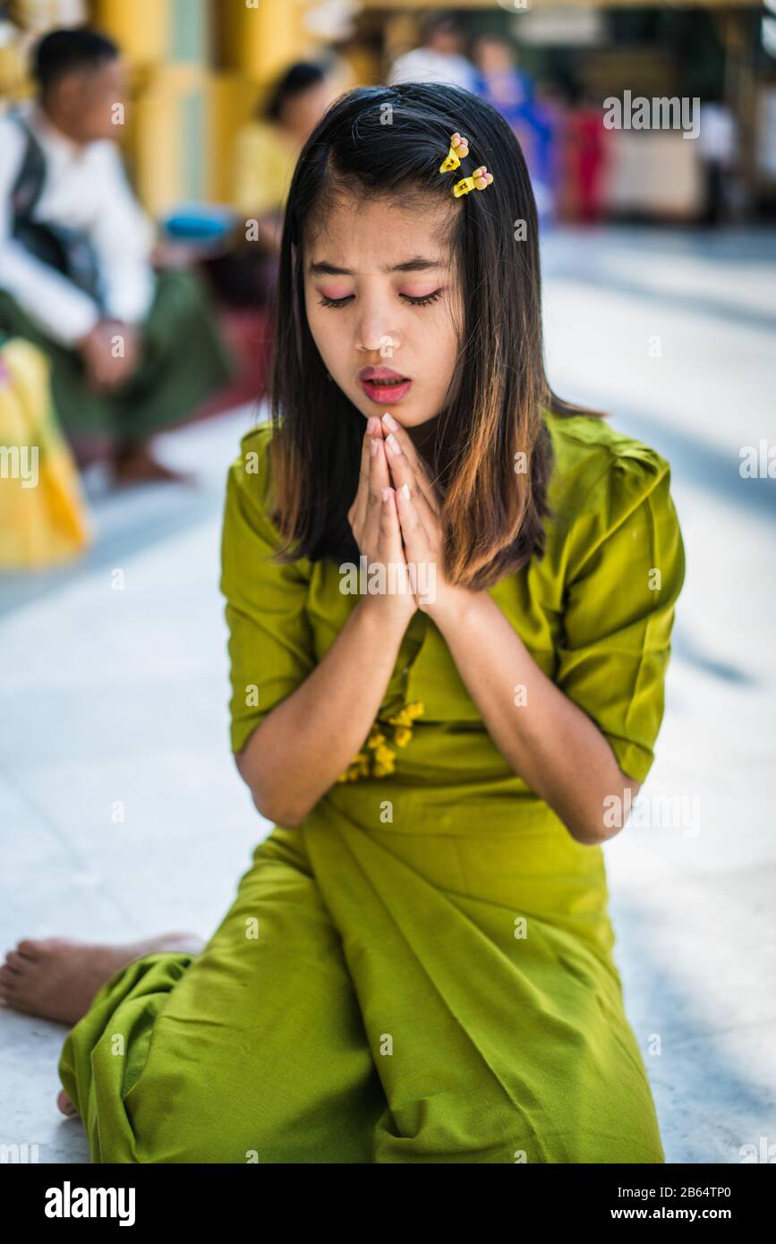 Young girl praying in the Shwedagon Pagoda, Yangon, Myanmar, Asia Stock Photo