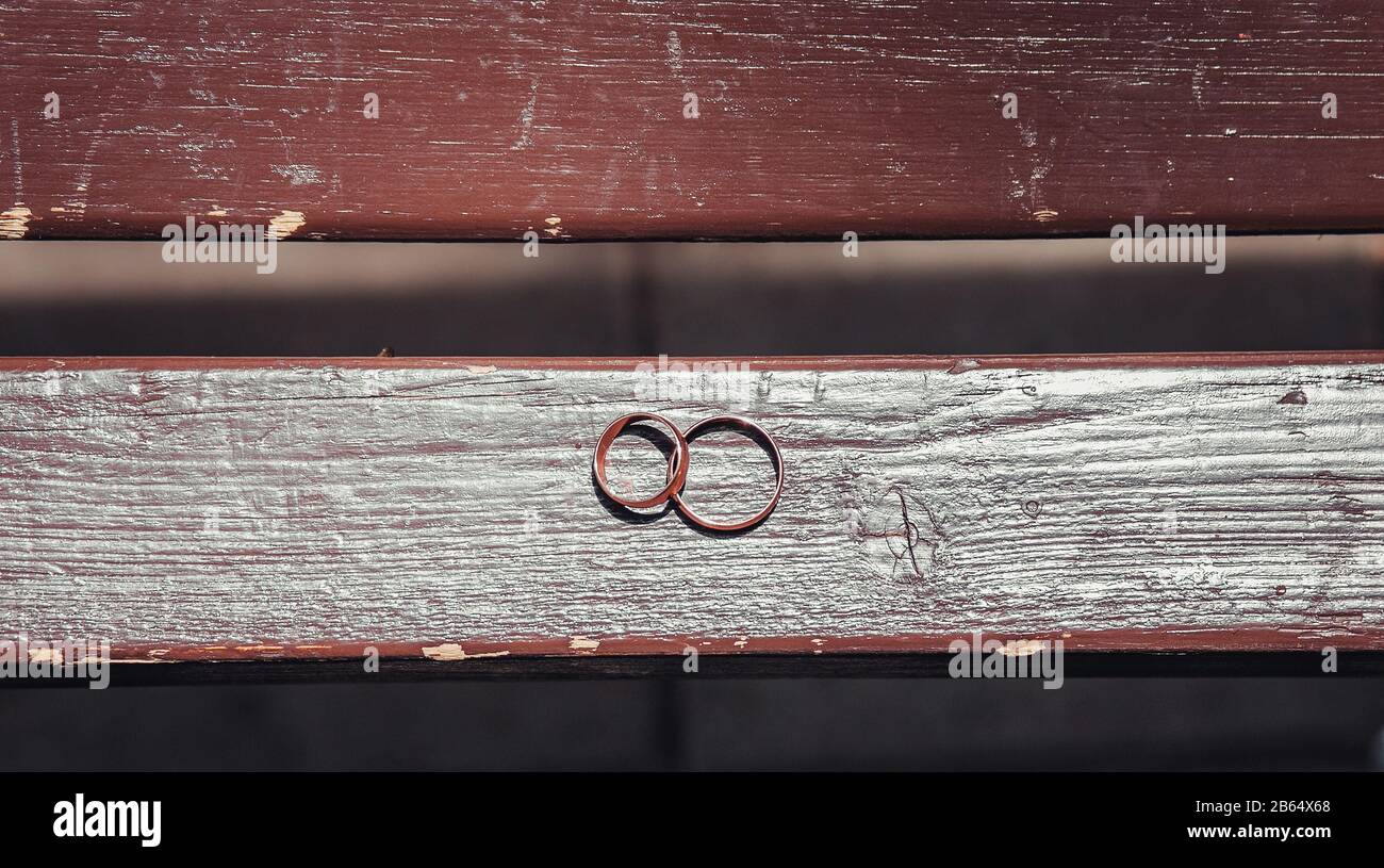 gold wedding rings on a wooden bench Stock Photo Alamy