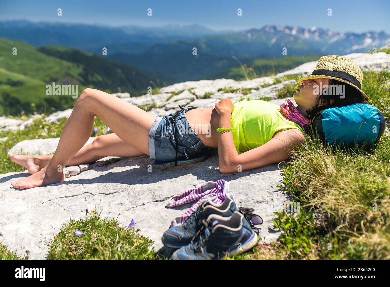 Woman tourist lying and sleeping or resting on top of the mountain. The concept of outdoor recreation Stock Photo