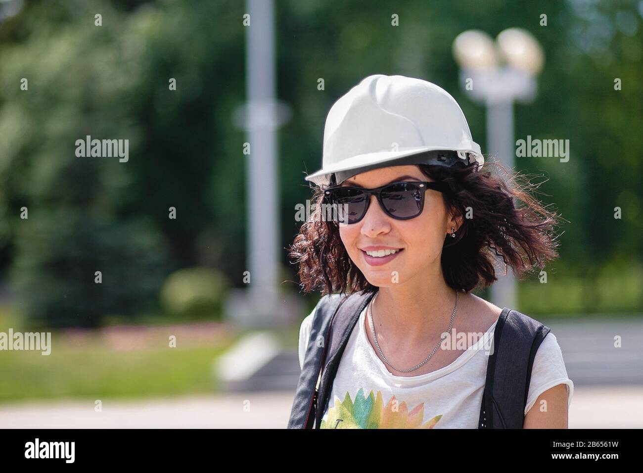 a woman in the construction helmet with sunglasses smiling Stock Photo