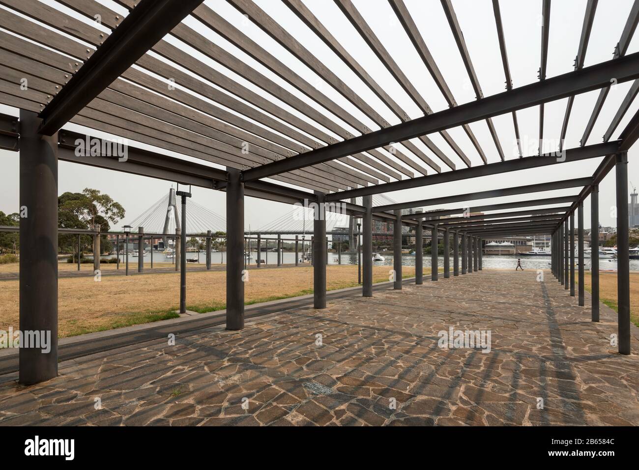 An artistic steel and timber structure frames a path that leads down to a park at Blackwattle Bay in Sydney Harbour, New South Wales, Australia Stock Photo