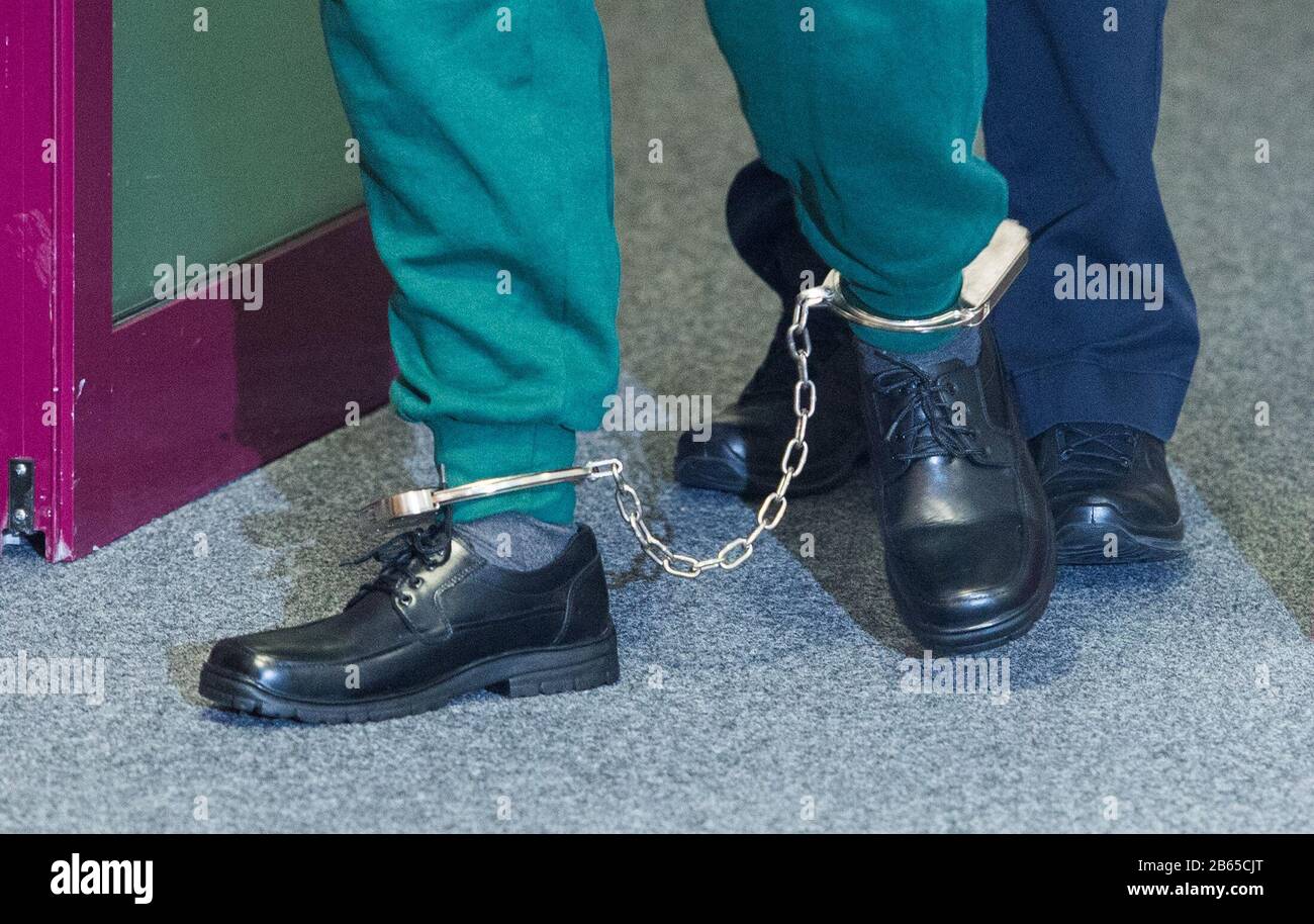 10 March 2020, Schleswig-Holstein, Lübeck: An accused prisoner goes into  the courtroom of the regional court and wears shackles on his feet. The man  is said to have taken a psychologist hostage