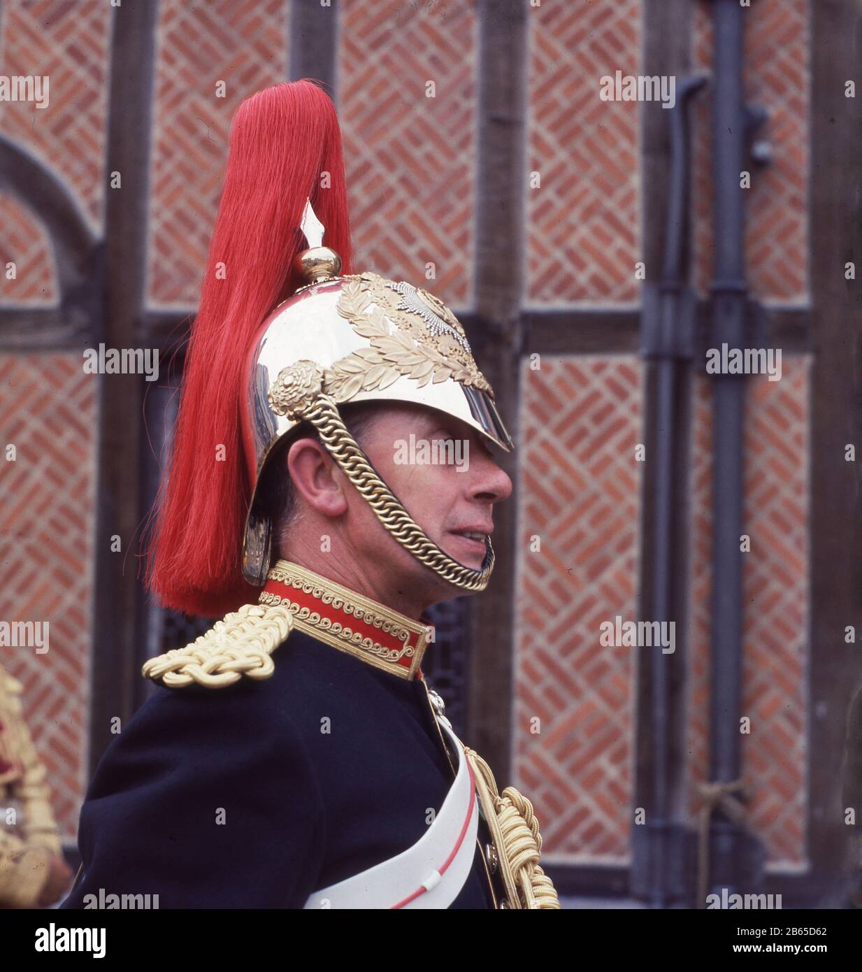 1960s, historical, close-up of the face and polished steel and gold helmet of a British Horse Guardsman, Windsor Castle, Windsor & Eton, Berkshire, England, UK, a member of the Royal Regiment of Horse Guards, known as the Blues, a cavalry regiment of the British Army, part of the Household Cavalry. The Blues merged with another regiment, the Royal Dragoons in 1969. Stock Photo
