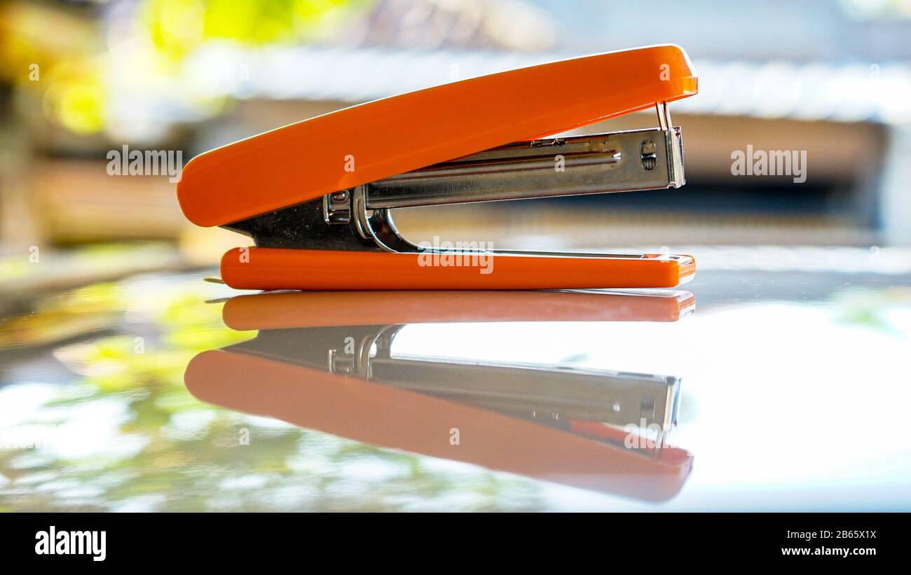 Close up of the orange stapler on the table Stock Photo