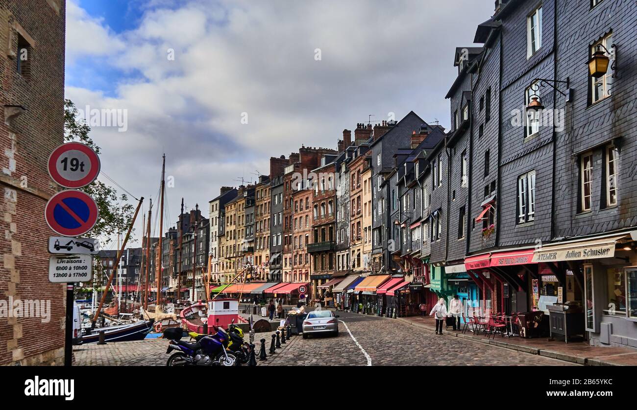 France, Normandie , Honfleur city, This is a popular resort town for both the French and foreigners. Originally a fishing village, it is now a tourist destination, on the cobblestones of Sainte Catherine quai on the left side of the street is the mooring area in the inner harbor for pleasure craft and sailboats. The right sidethe right side is lined with houses and sidewalk cafes on the ground level.. Stock Photo